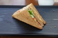 A single Tuna sandwich on black serving plate. One Club Sandwich with chicken, ham, cheese, tomatoes, cucumber, bacon, lettuce, Royalty Free Stock Photo