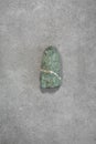 Single Turquoise Stone on a Gray Grunge Granite Structure Background. Royalty Free Stock Photo