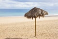 Single umbrella on lonely beach. Isolates parasol on Canary beach with beautiful sand