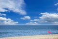 Single umbrella on the pebbly beach against the picturesque cloudy sky Royalty Free Stock Photo