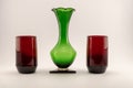 Single vintage green vase and two red candle holders Royalty Free Stock Photo