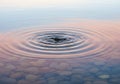 Single water droplet creating ripple effect on calm surface macro view Royalty Free Stock Photo
