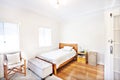 Single white bedroom with polished wood floor