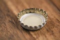 Single white beer bottle cap on wood table Royalty Free Stock Photo