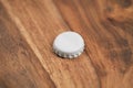 Single white beer bottle cap on wood table Royalty Free Stock Photo