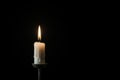 Single white burning candle on black background. Funeral, mourning, memorial service concept Royalty Free Stock Photo