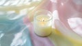 A single white candle glowing softly in a glass jar, set on a pastel tablecloth pic Royalty Free Stock Photo