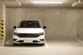 Single white car in an empty parking lot in an underground parking Royalty Free Stock Photo