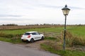 Single White Car Parked along a Rural Green Grass Field in Zaanse Schans Netherlands