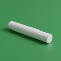 A single white chalk stick lies on a solid green surface. The chalk is cylindrical, Royalty Free Stock Photo