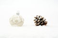 Single white christmas bauble with pine cone on snow isolated Royalty Free Stock Photo