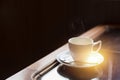 Single white cup of espresso hot coffee with morning sun light from windows Royalty Free Stock Photo