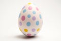 Single white Easter egg painted with colorful dots on white background Royalty Free Stock Photo