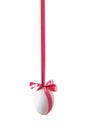 Single white egg hanged on the pink satin ribbon