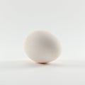 A single white egg with a smooth, even texture rests on a white surface. Its oval shap Royalty Free Stock Photo