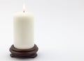 Single white lit candle on white background Royalty Free Stock Photo