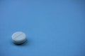 Single white pill on a blue background with copy space Royalty Free Stock Photo