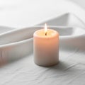 A single white pillar candle burns brightly, positioned on a smooth, Royalty Free Stock Photo