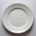 A single white porcelain plate is centered on a white background. The plate is mostly Royalty Free Stock Photo