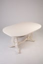 Single white round table with empty surface and carved legs on an isolated