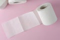 Single white toilet paper roll on pastel pink background. Space for text. Everyday use object. Royalty Free Stock Photo