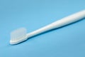 Single white toothbrush close up isolated on blue background diagonal Royalty Free Stock Photo