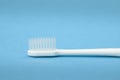Single white toothbrush close up isolated on blue background horizontal Royalty Free Stock Photo