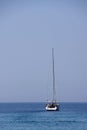 Single white yacht with furled sail