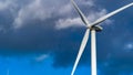 Single wind turbine set against a dark cloudy sky Royalty Free Stock Photo