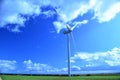 Single Wind Turbine in a green field against a blue sky Royalty Free Stock Photo