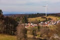 A single wind turbine on a hill above a village with the distant skyline of Frankfurt Royalty Free Stock Photo