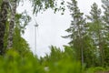 Single Wind Turbine in the middle of the green forest under blue sky with clouds. Windfarm, wind power plant Royalty Free Stock Photo