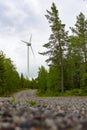 Single Wind Turbine in the middle of the green forest under blue sky with clouds. Windfarm, wind power plant Royalty Free Stock Photo