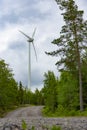 Single Wind Turbine in the middle of the green forest under blue sky with clouds. Windfarm, wind power plant Royalty Free Stock Photo