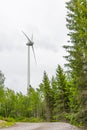 Single Wind Turbine in the middle of the green forest under blue sky with clouds. Windfarm, wind power plant Royalty Free Stock Photo