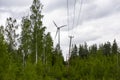 Single Wind Turbine in the middle of the green forest under blue sky with clouds. Windfarm, wind power plant Royalty Free Stock Photo