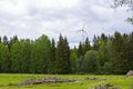 Single Wind Turbine in the middle of the green forest under blue sky with clouds. Windfarm, wind power plant Royalty Free Stock Photo