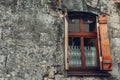 Single window in old wall. Ancient stone house. Wooden window with curtains Royalty Free Stock Photo