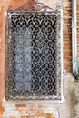 Single window with rusted metal bars on an old semi-destroyed brick wall in Venice, Italy Royalty Free Stock Photo