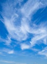 Wispy white clouds against a deep blue sky. UK. Upright Royalty Free Stock Photo