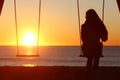 Single woman alone swinging on the beach Royalty Free Stock Photo