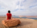 Single woman meditating in front of a lake