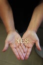 A single woman with her hands together with wooden letters forming the word Yes Royalty Free Stock Photo