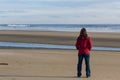 woman with red jacket at a beach Royalty Free Stock Photo