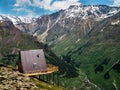 Single wooden house with a red roof on a hill high in the mountains with a beautiful view of the green valley on a Sunny day Royalty Free Stock Photo