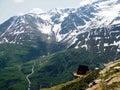 Single wooden house with a red roof on a hill high in the mountains with a beautiful view of the green valley on a Sunny day Royalty Free Stock Photo