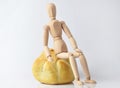 Single wooden puppet sitting on a bun Royalty Free Stock Photo