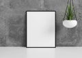 Single 8x10 Vertical Pink Frame mockup with green plant in vase on white floor and concrete wall behind it Royalty Free Stock Photo