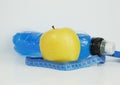 Single yellow apple, blue drink, and ruler on the white background. Royalty Free Stock Photo