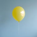 Single Yellow Balloon Floating Against a Light Blue Wall helium Royalty Free Stock Photo